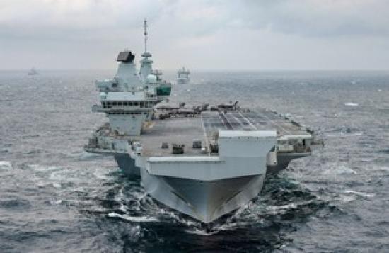 Photograph of Royal Navy aircraft carrier in final preparation to lead multinational deployment to Mediterranean and Indo-Pacific